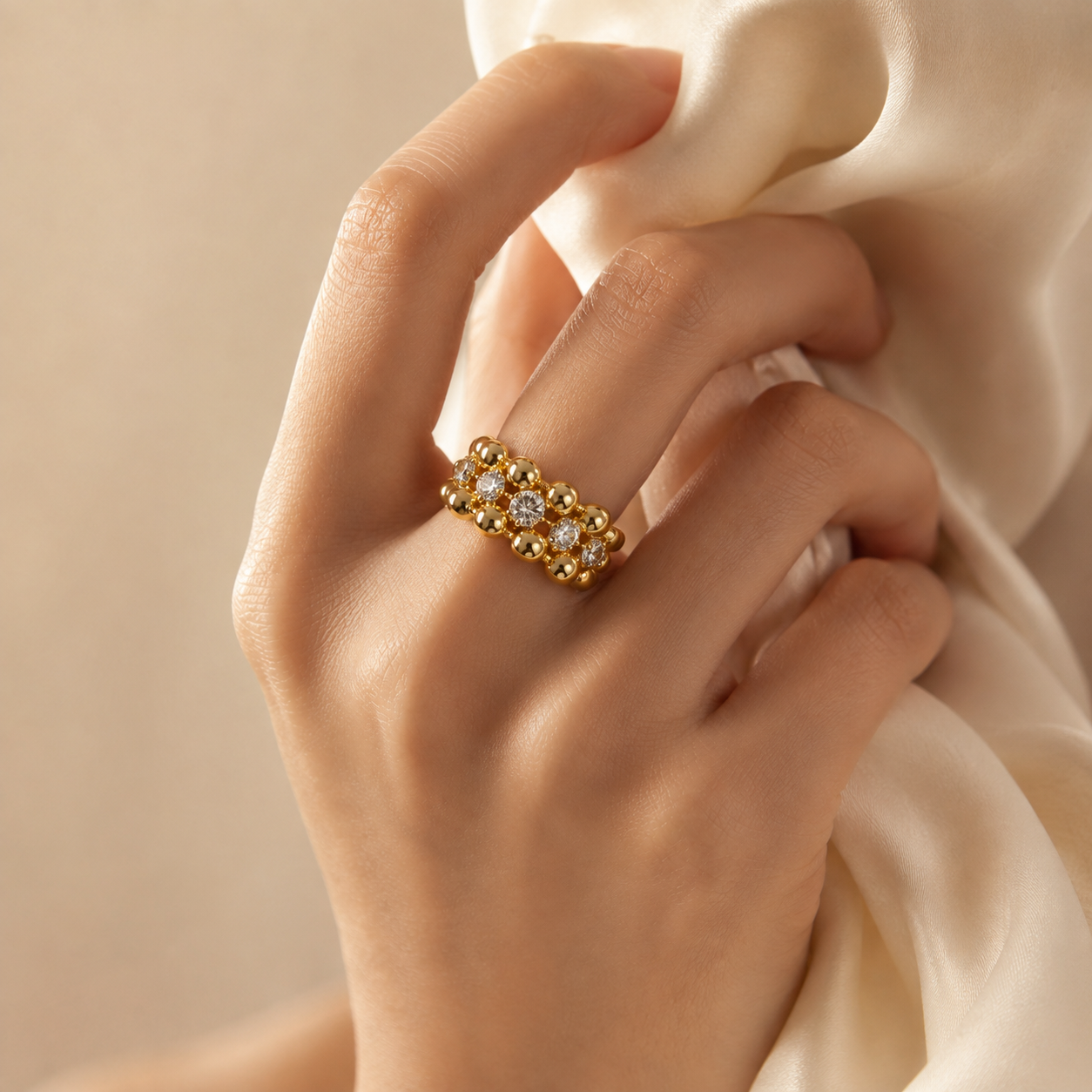Close-up of a woman wearing a heavy 18K gold-plated beaded cubic zirconia ring