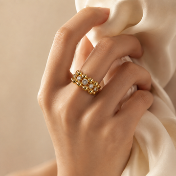 Close-up of a woman wearing a heavy 18K gold-plated beaded cubic zirconia ring