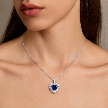 Close-up of a woman wearing a 4-carat heart-shaped blue sapphire pendant necklace with sparkling 5A cubic zirconia