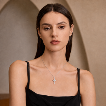 Woman wearing the Crowned in Grace moissanite cross necklace with a black dress