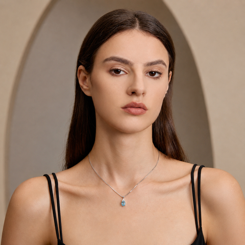 Model wearing Starlit Garden aquamarine blue spinel necklace with moissanite accents