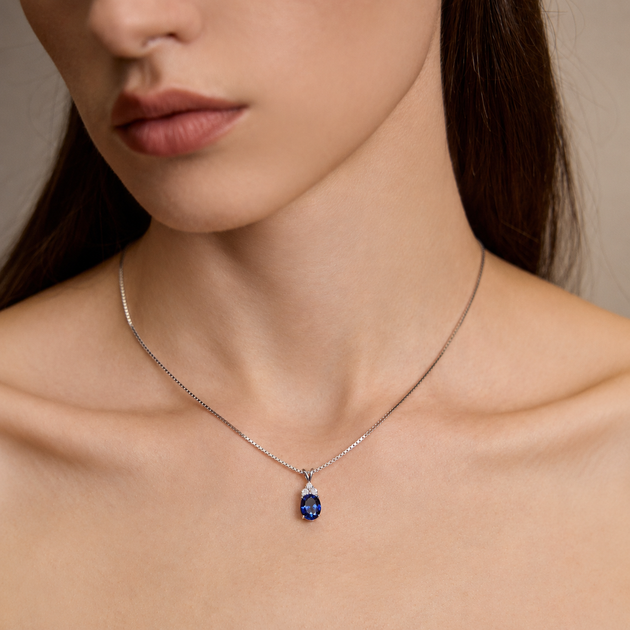 Close-up of model wearing Starlit Garden royal blue sapphire necklace with moissanite accents
