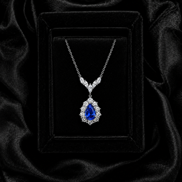 Seafoam Reverie pear-cut royal blue sapphire necklace displayed on black velvet