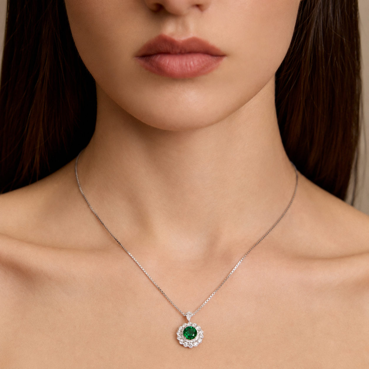 Model wearing the Moon Halo Emerald Necklace with a vivid green lab-grown emerald and moissanite halo pendant