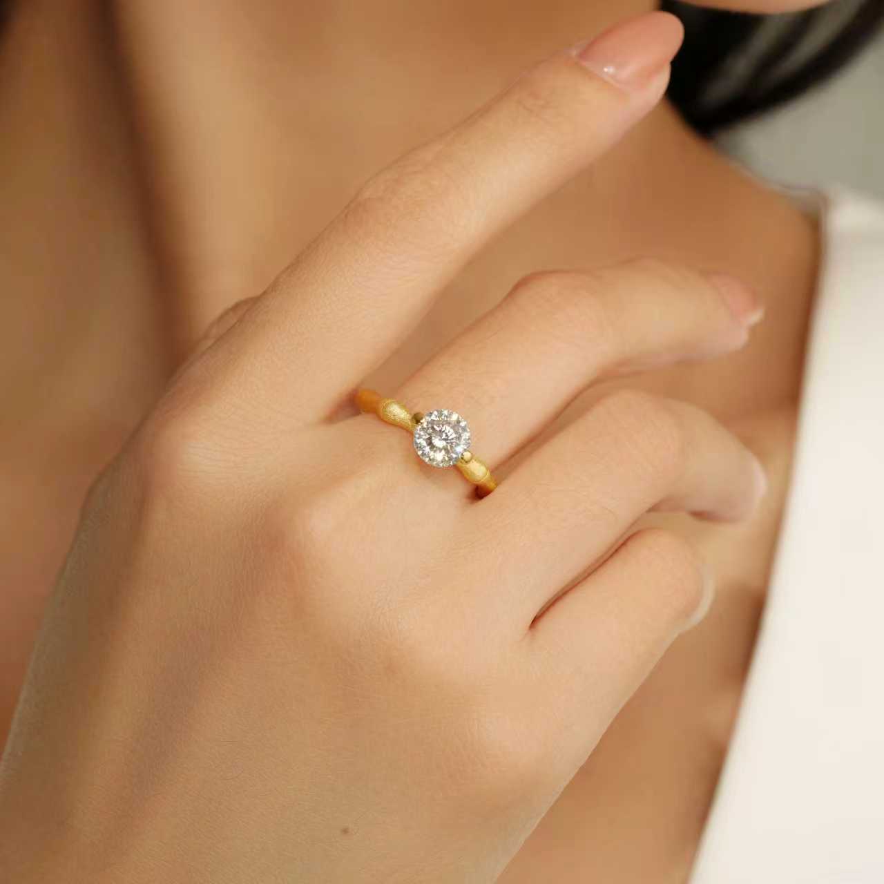 Eve’s Embrace D-color moissanite solitaire ring worn on hand in heavy 18K gold plated 925 sterling silver