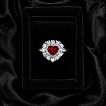 Heart-shaped lab-grown ruby ring with sparkling moissanite halo in 925 sterling silver, displayed in a black velvet gift box