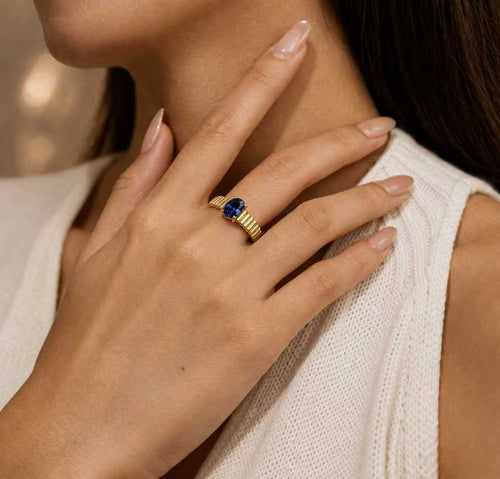 Model wearing Love Ladder oval lab-grown blue sapphire ring in heavy 18K gold plated 925 sterling silver
