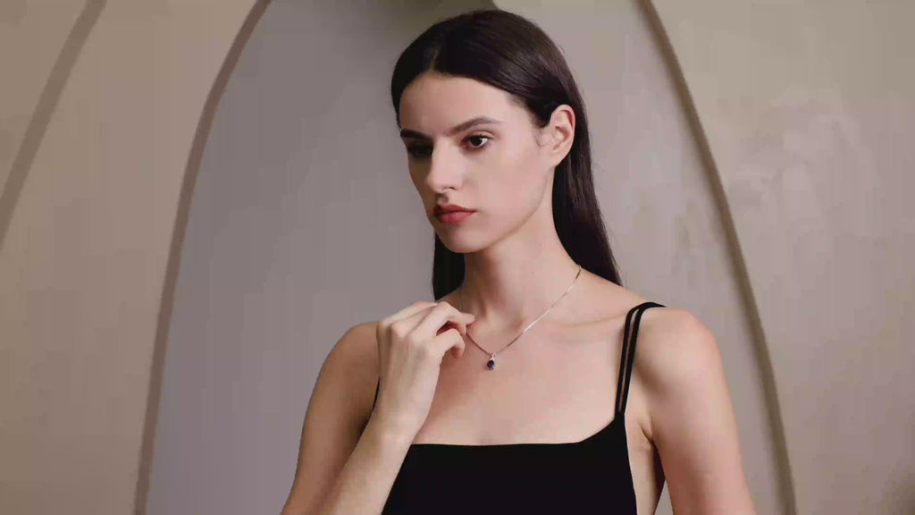 Model wearing Starlit Garden royal blue sapphire necklace with moissanite accents