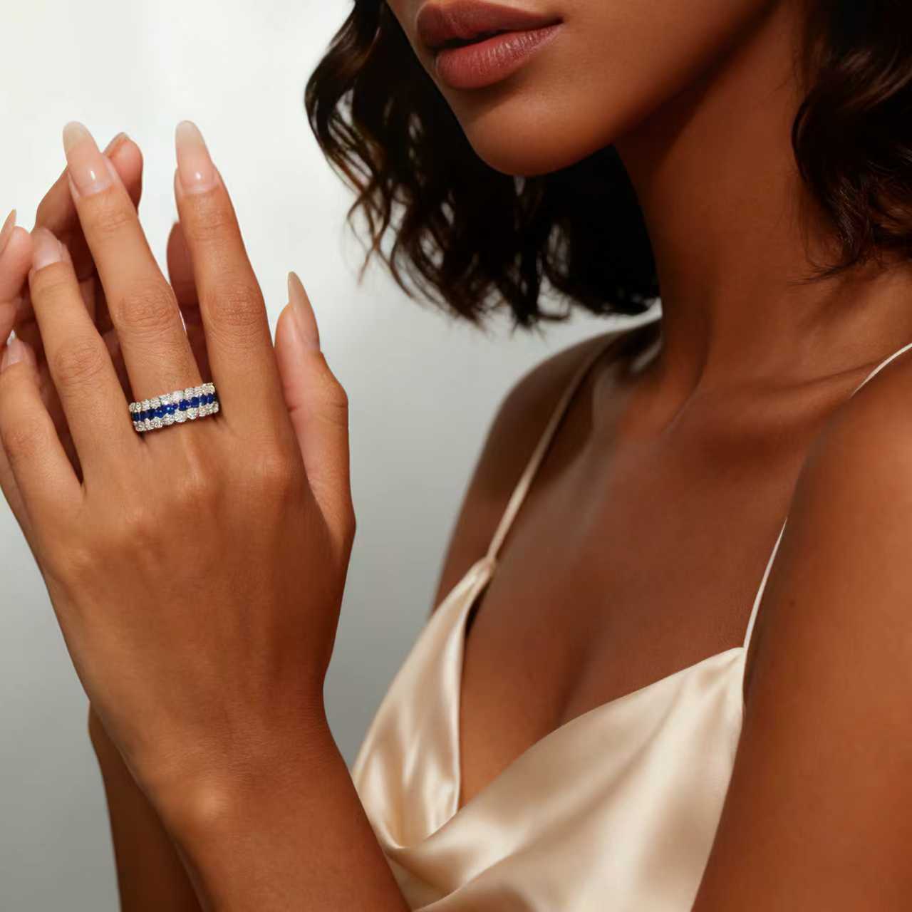 Model wearing a three-row lab-grown blue sapphire and moissanite ring in rhodium-plated 925 sterling silver